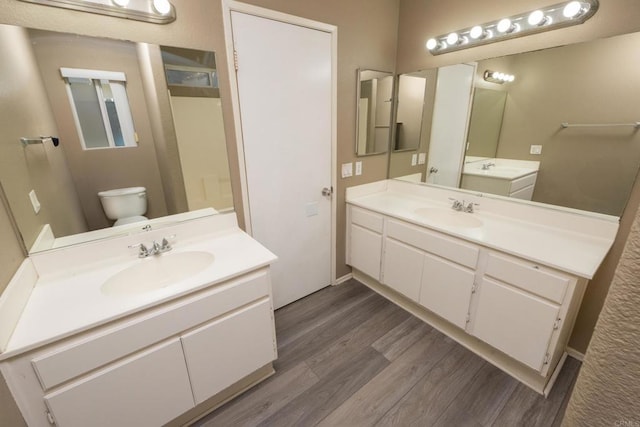 bathroom with toilet, vanity, and hardwood / wood-style flooring