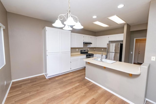 kitchen featuring stainless steel appliances, white cabinetry, pendant lighting, and sink