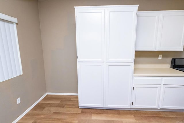 kitchen featuring white cabinets and light hardwood / wood-style flooring