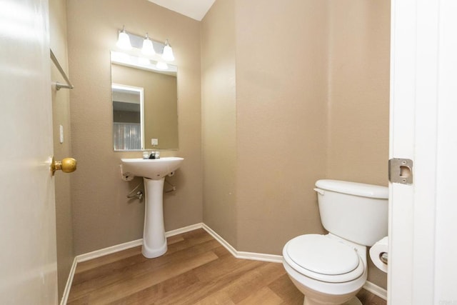 bathroom with hardwood / wood-style floors and toilet