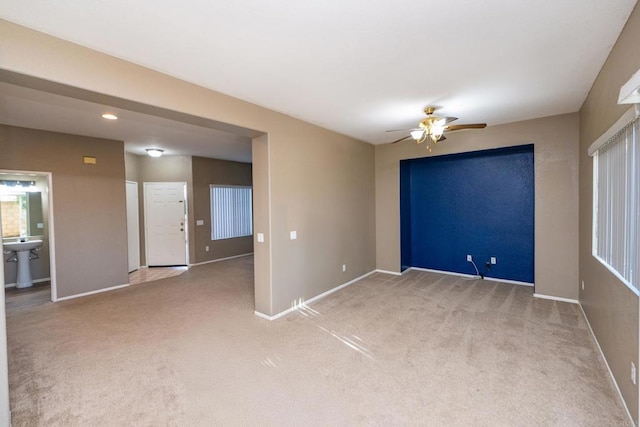 carpeted spare room with sink and ceiling fan