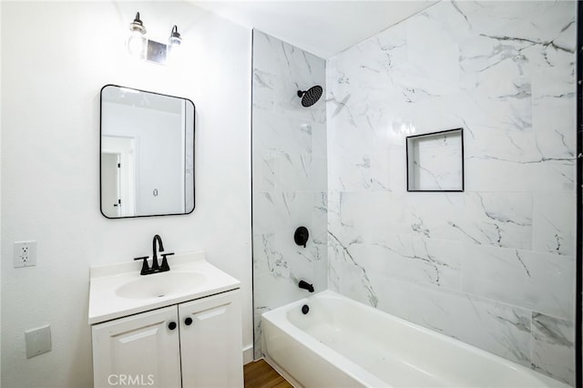 bathroom featuring tiled shower / bath, hardwood / wood-style flooring, and vanity