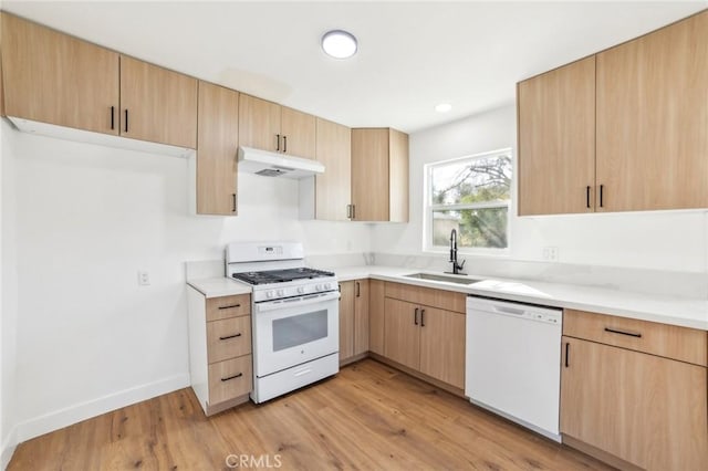 kitchen with light brown cabinetry, sink, white appliances, and light hardwood / wood-style floors