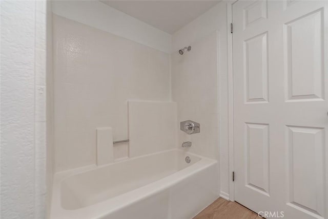 bathroom with bathing tub / shower combination and hardwood / wood-style flooring