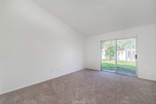 carpeted spare room featuring high vaulted ceiling