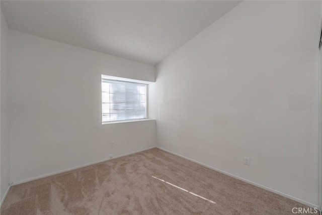 carpeted spare room with lofted ceiling