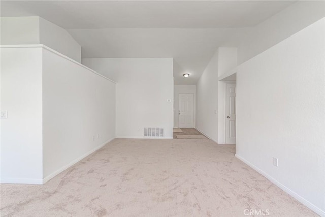 additional living space featuring vaulted ceiling and light colored carpet