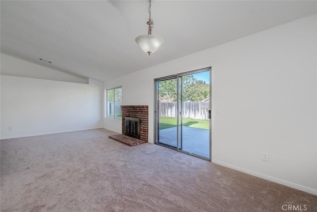 unfurnished living room with a brick fireplace, vaulted ceiling, and carpet flooring