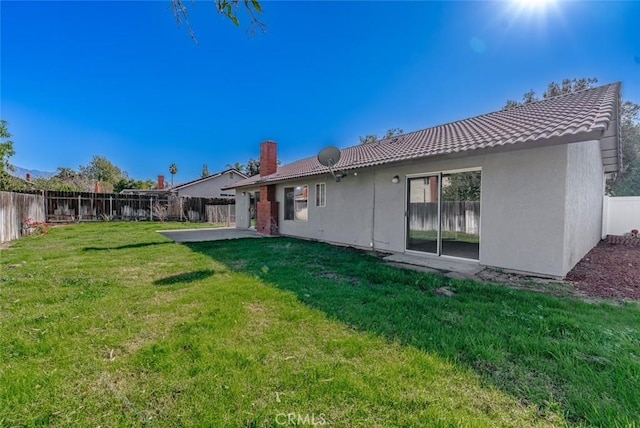 back of house with a patio area and a lawn