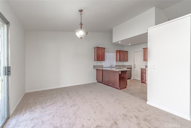 kitchen with sink, a kitchen breakfast bar, pendant lighting, and light carpet