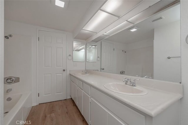 bathroom featuring  shower combination, vanity, and hardwood / wood-style flooring