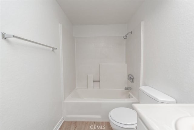 bathroom featuring bathing tub / shower combination, toilet, and wood-type flooring