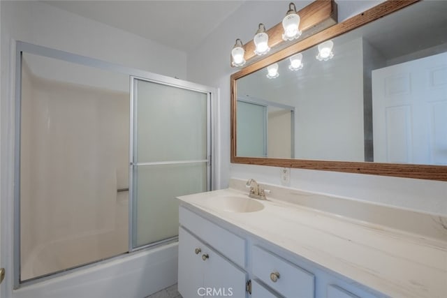 bathroom featuring combined bath / shower with glass door and vanity