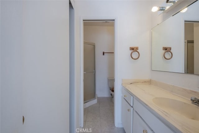 bathroom with toilet, vanity, and a shower with shower door