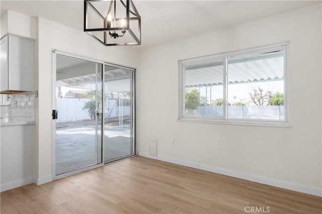 interior space featuring light wood-type flooring and an inviting chandelier