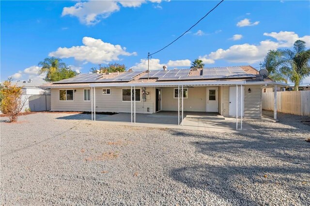 rear view of house featuring a patio and solar panels