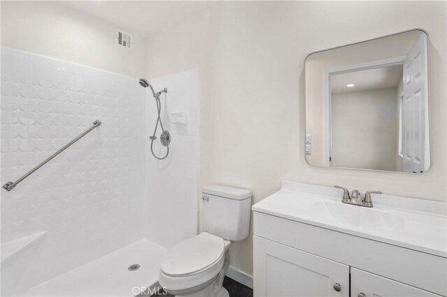 bathroom with toilet, a shower, and vanity