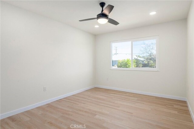 spare room with ceiling fan and light wood-type flooring