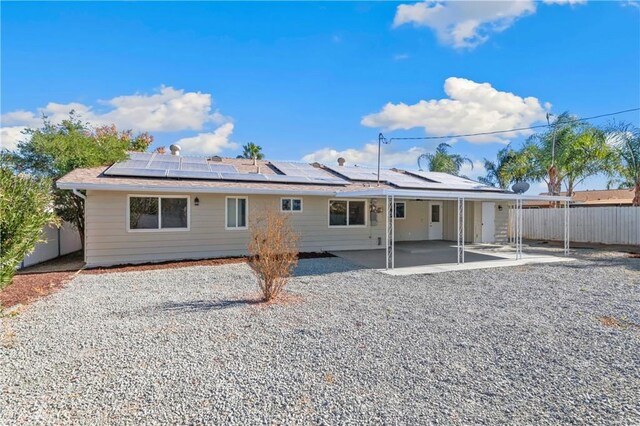 rear view of property with solar panels