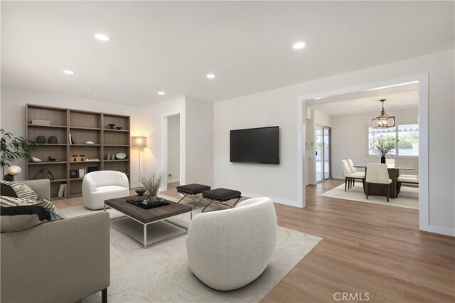 living room with a notable chandelier and light hardwood / wood-style flooring