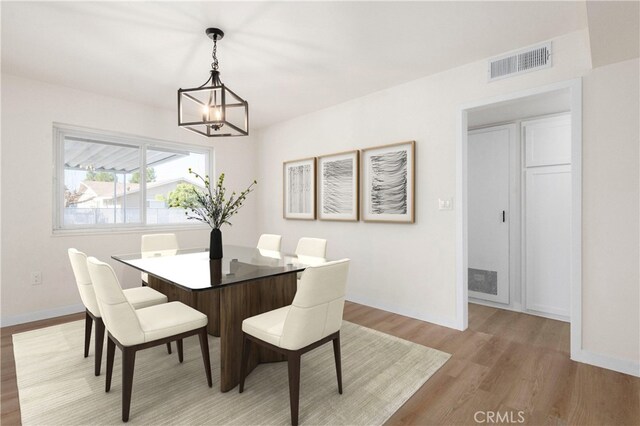 dining room featuring an inviting chandelier and light hardwood / wood-style flooring