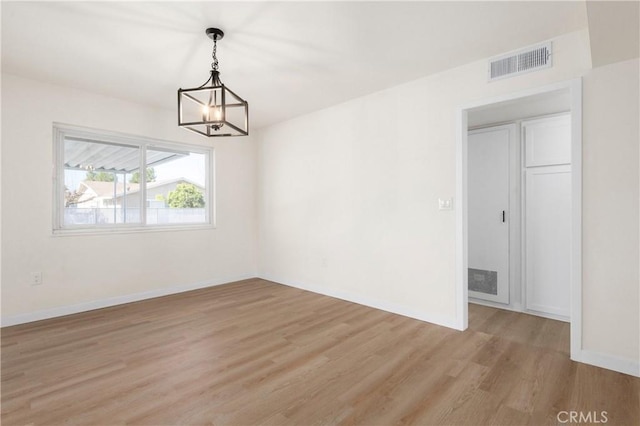 interior space featuring an inviting chandelier and light hardwood / wood-style flooring