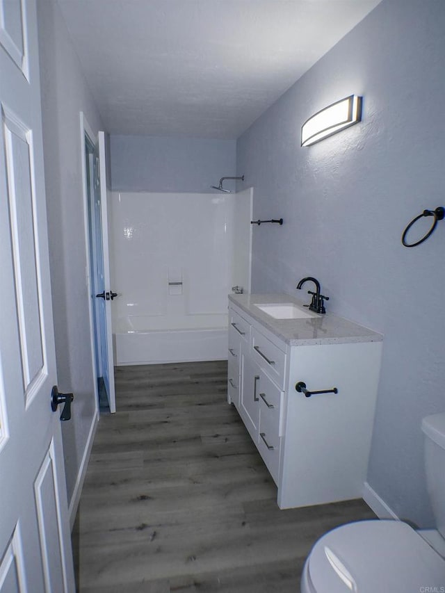 full bathroom featuring toilet, hardwood / wood-style flooring, shower / tub combination, and vanity