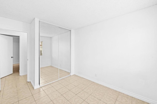 unfurnished bedroom with a closet and light tile patterned floors