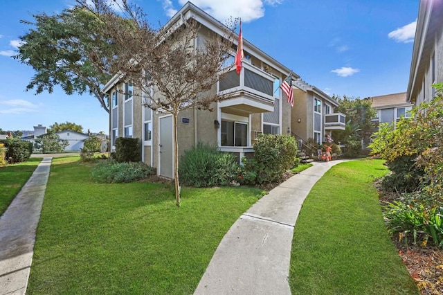 view of front facade featuring a balcony and a front lawn