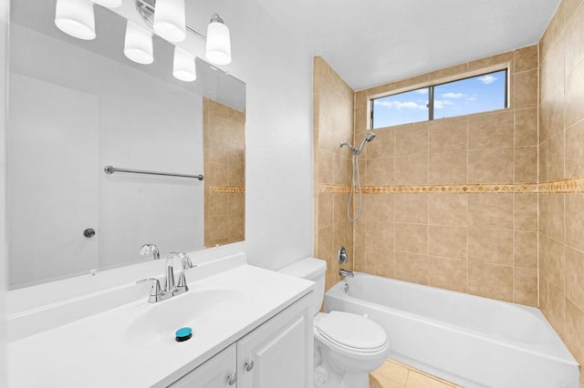 full bathroom featuring vanity, tile patterned flooring, tiled shower / bath combo, and toilet