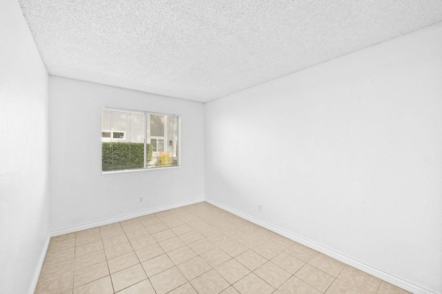 tiled spare room featuring a textured ceiling