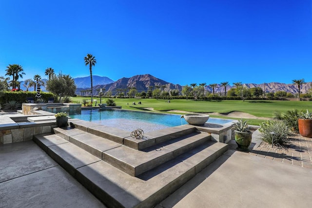 view of swimming pool with an in ground hot tub, a yard, and a mountain view