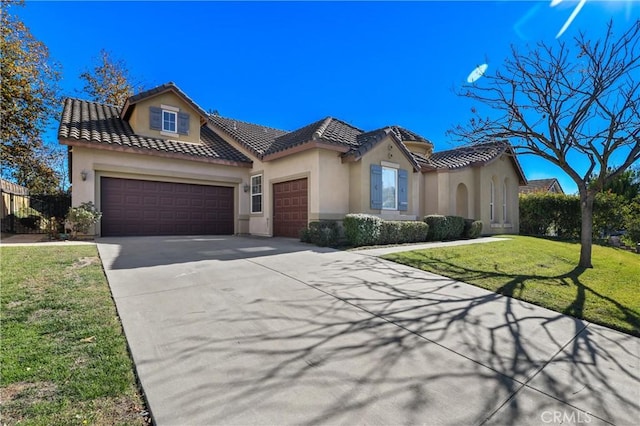 mediterranean / spanish home with a garage and a front lawn