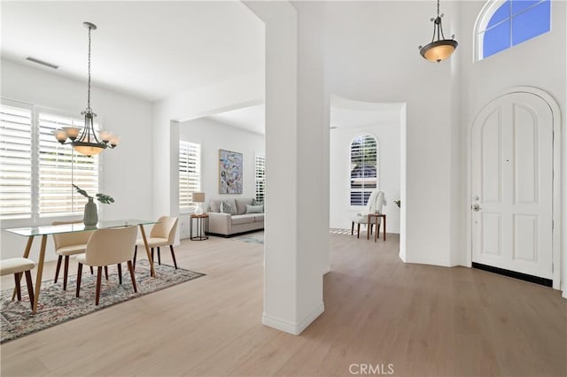 entrance foyer with a notable chandelier and light hardwood / wood-style flooring