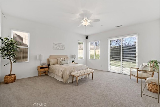 carpeted bedroom with ceiling fan, access to outside, and multiple windows