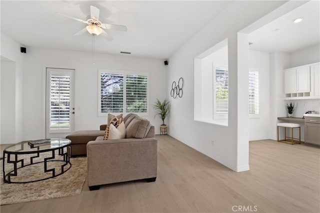 living room with light wood-type flooring and ceiling fan