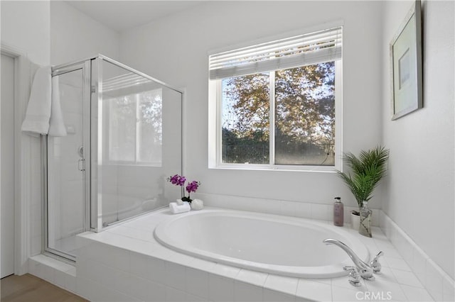 bathroom featuring shower with separate bathtub