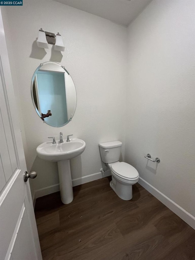 bathroom with hardwood / wood-style floors and toilet