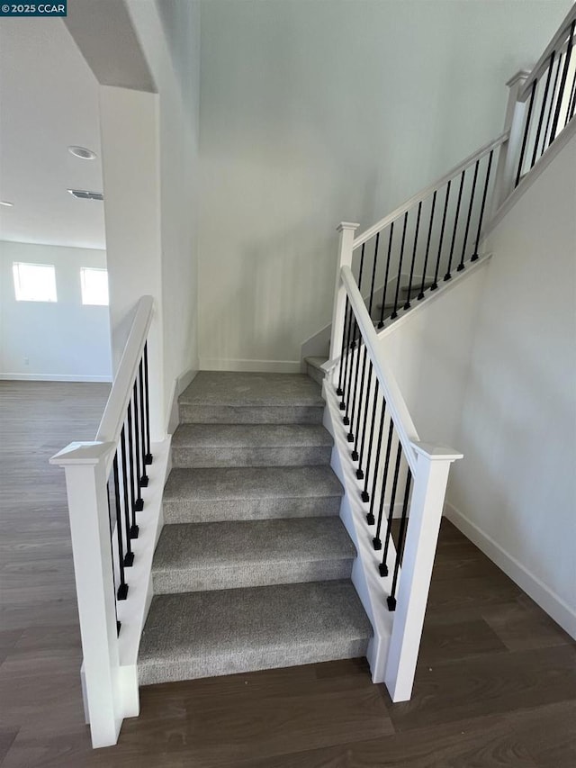 staircase with hardwood / wood-style floors