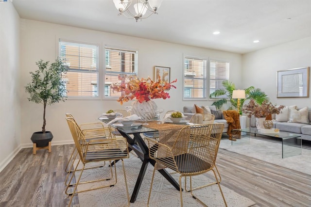 dining space with hardwood / wood-style floors and a chandelier