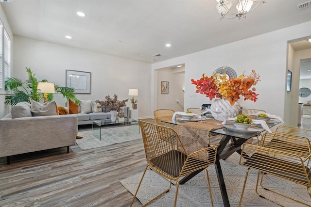 dining space with a notable chandelier and hardwood / wood-style floors