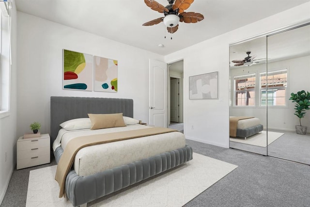 carpeted bedroom featuring ceiling fan and a closet