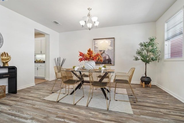 dining room featuring hardwood / wood-style flooring and a notable chandelier