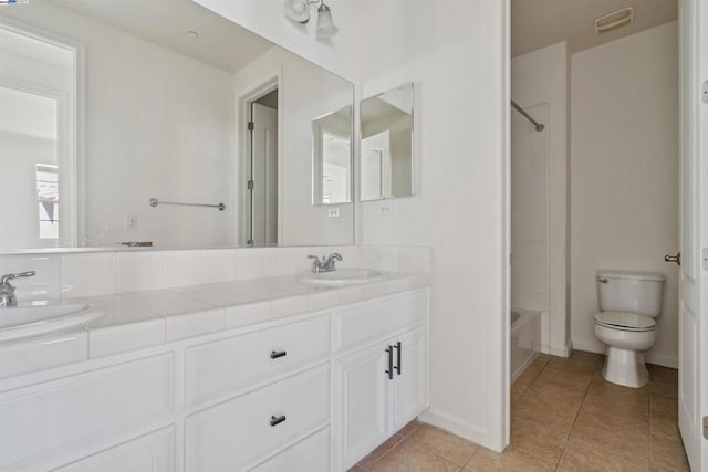 full bathroom featuring washtub / shower combination, vanity, tile patterned floors, and toilet