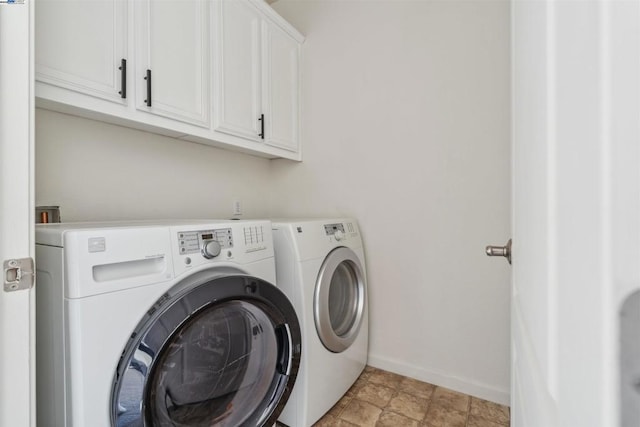 laundry room featuring washing machine and dryer and cabinets