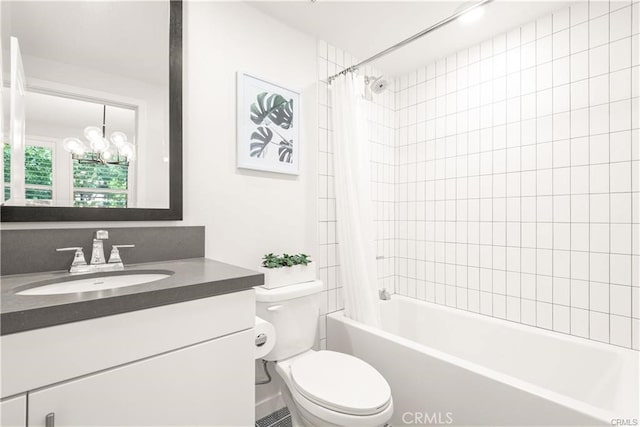 full bathroom with vanity, a chandelier, shower / bath combo with shower curtain, and toilet