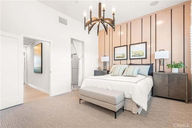 bedroom with light colored carpet and a notable chandelier