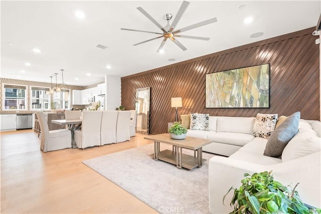 living room featuring wood walls and ceiling fan