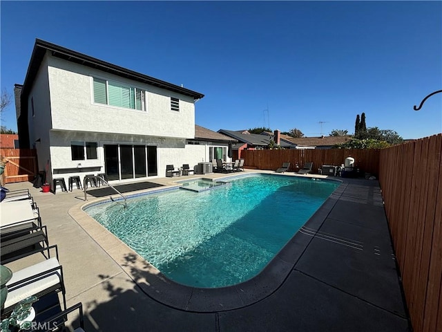 view of swimming pool with cooling unit and a patio area