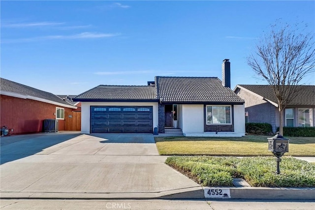 ranch-style home with a garage, cooling unit, and a front lawn